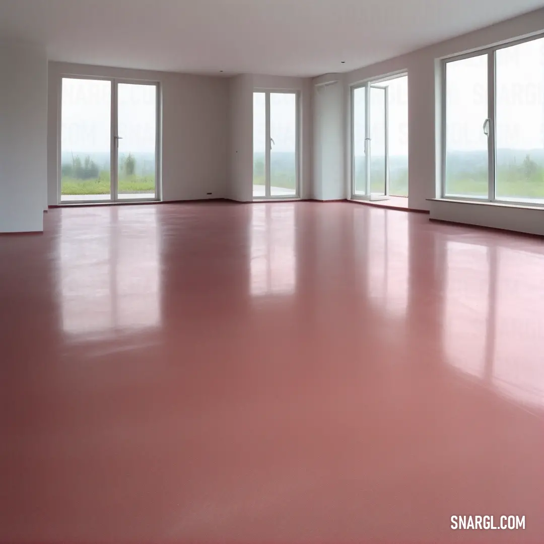 A spacious, uncluttered room capturing serenity with expansive windows that offer a panoramic view of scenic countryside landscapes, paired with elegant pink flooring that adds a unique softness to the environment.