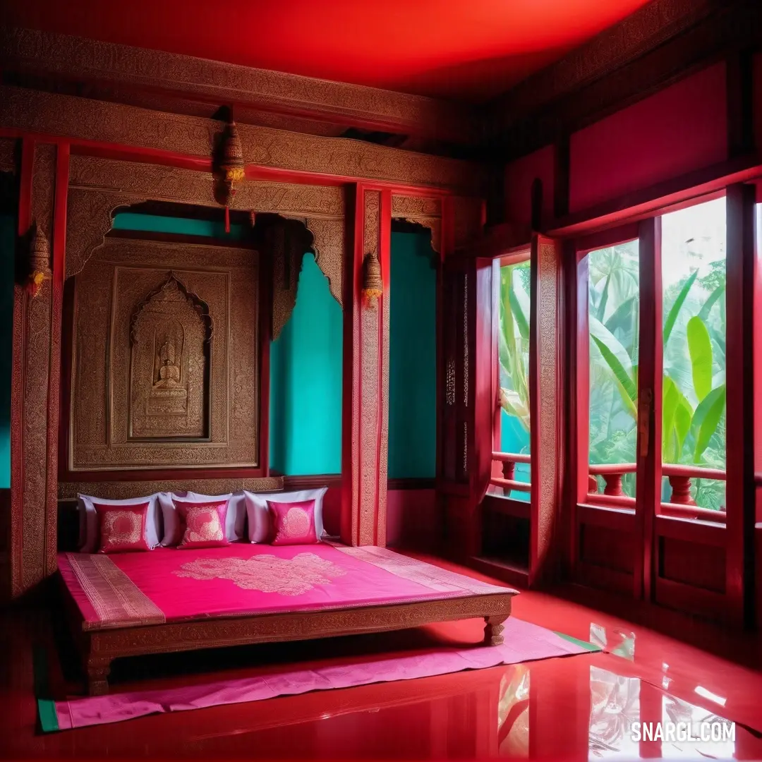 Bed with a pink blanket and pillows in a room with red walls and windows and a wooden headboard. Color Raspberry.
