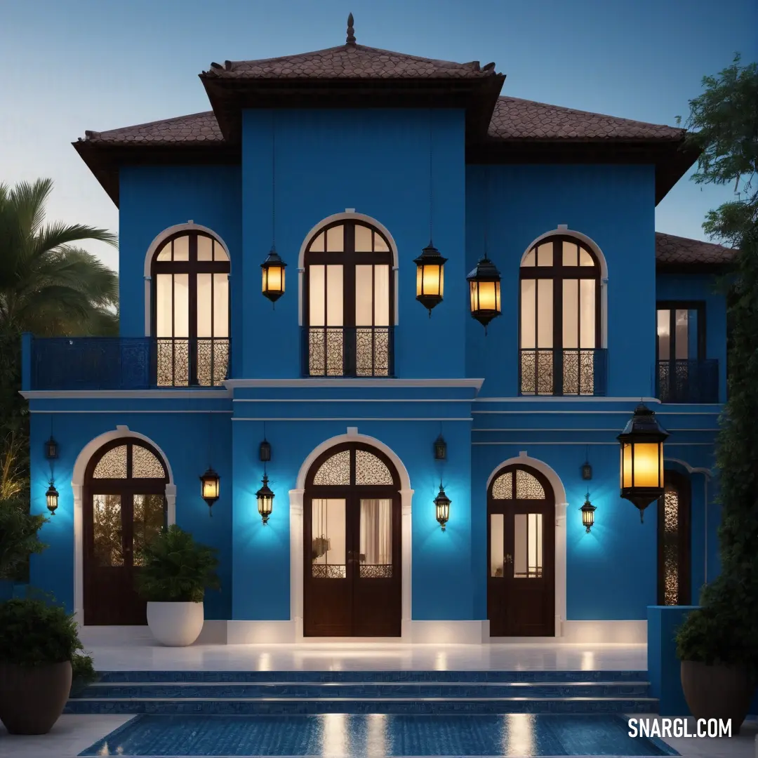 Blue house with a pool and a fountain in front of it at night time with lights on the windows. Example of CMYK 96,30,0,18 color.
