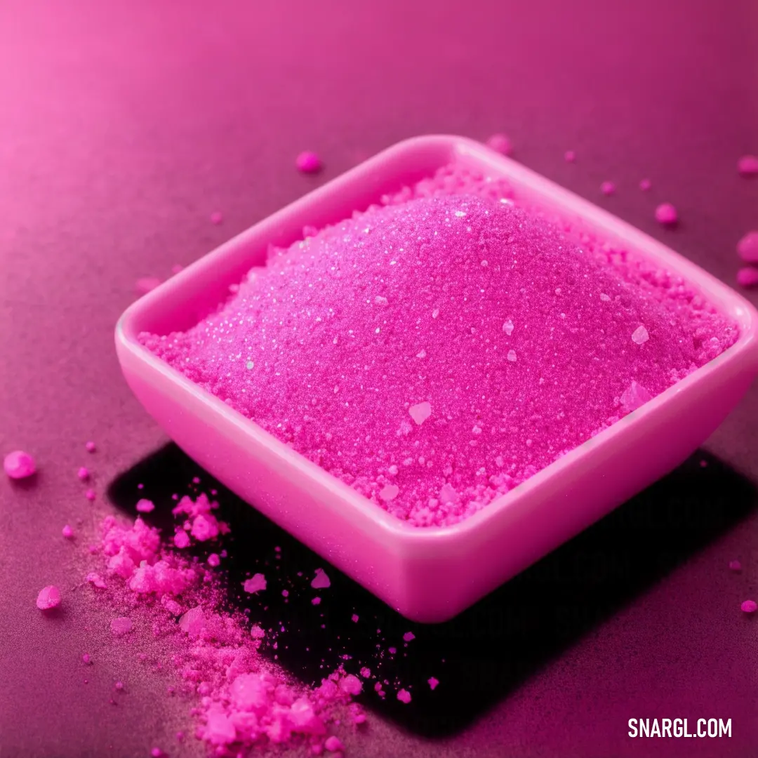 Pink bowl filled with pink colored powder on a table top with pink flakes scattered around it and a black background
