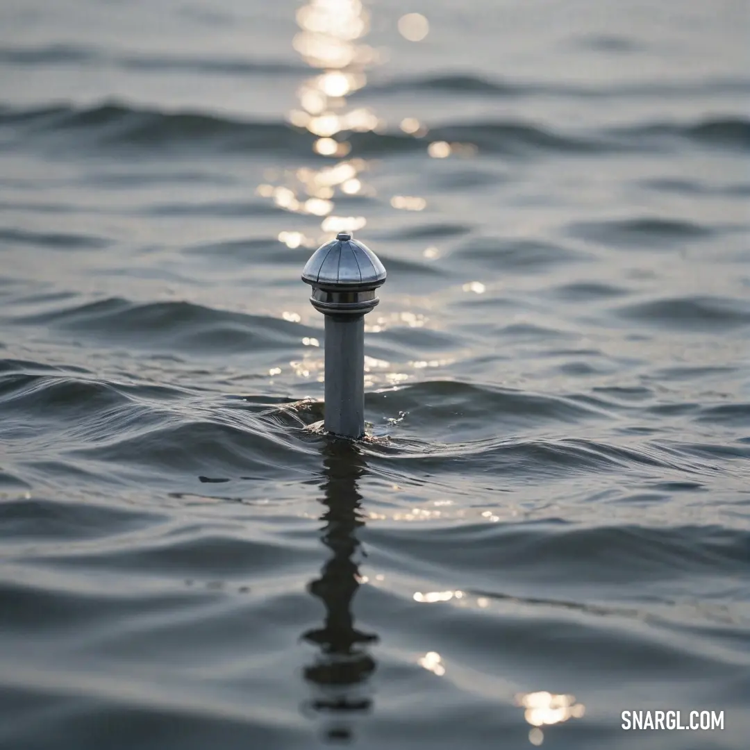 A solitary pole stands majestically in tranquil waters, reflecting the brilliant sun. Surrounding hues create a serene backdrop, encapsulating the beauty of nature's interplay between light and water.