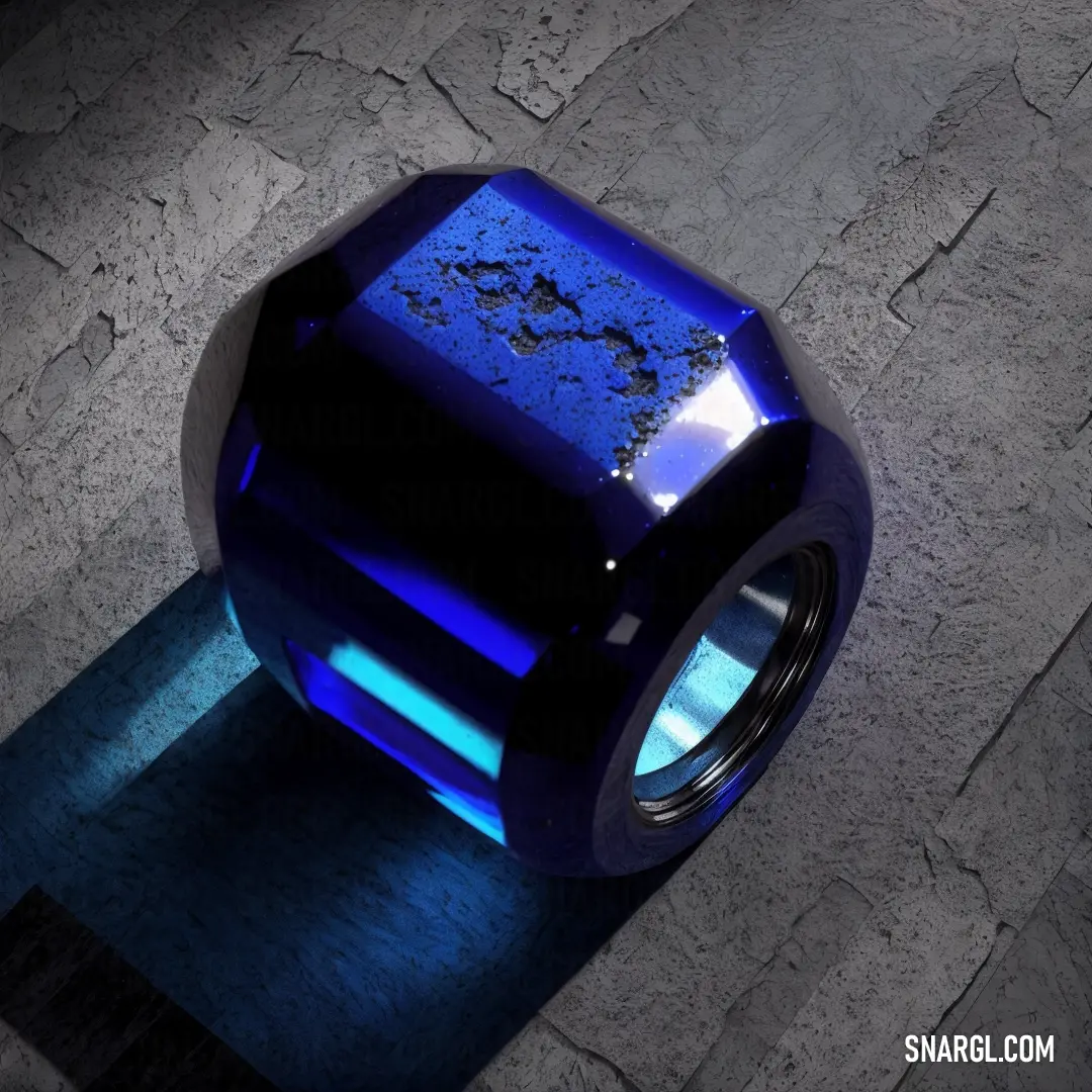 Blue object is on a stone floor with a blue light shining on it's side of it