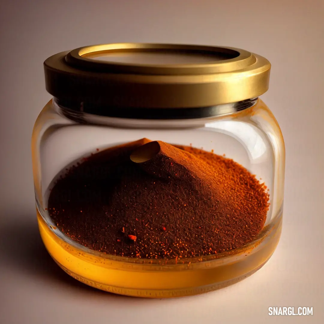 Jar filled with a mixture of spices on a table top with a spoon in it and a lid. Color CMYK 0,46,79,27.