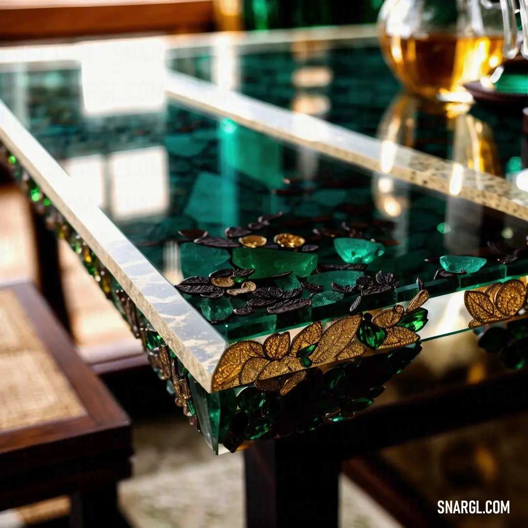 Glass table with a green and gold design on it and a wine glass on the table top