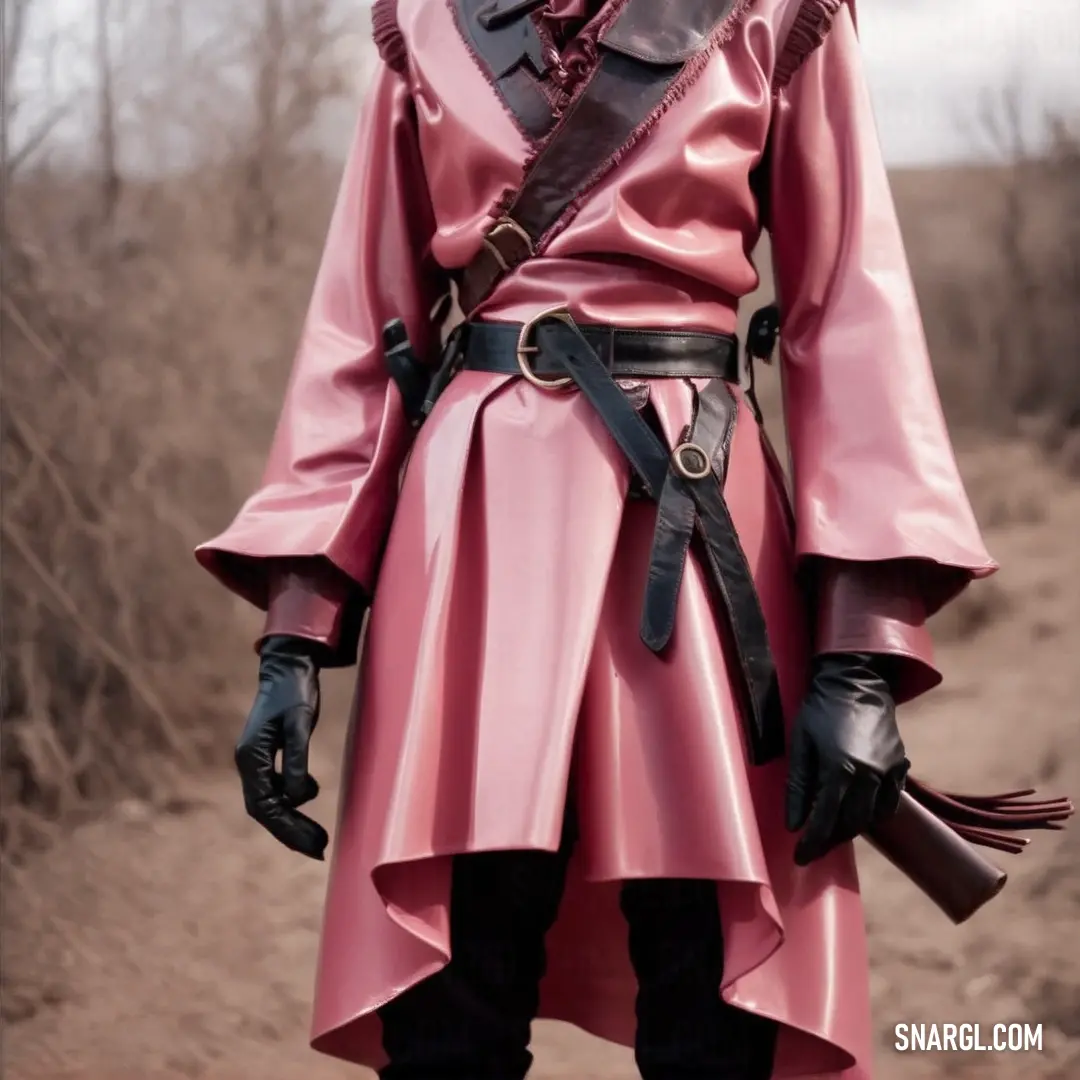 Man in a pink outfit and black gloves standing in a field with a gun in his hand and a hat on his head. Color RGB 255,145,164.