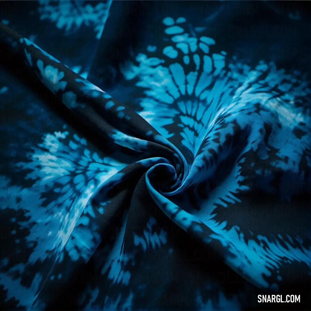 Blue and black tie - dyed fabric with a flower pattern on it. Example of Sea blue color.