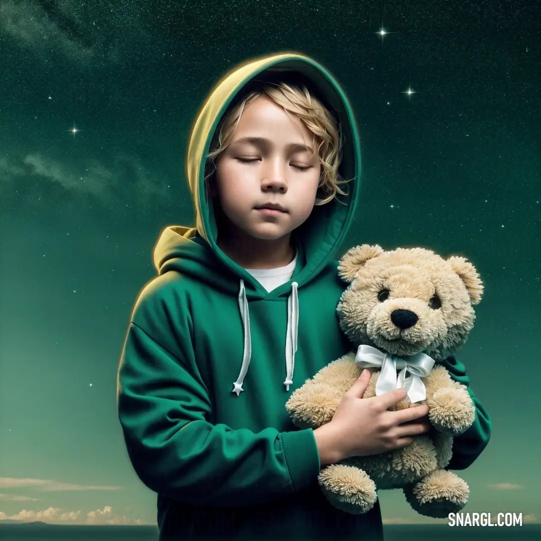 Young boy holding a teddy bear in his hands and wearing a green hoodie with a white bow