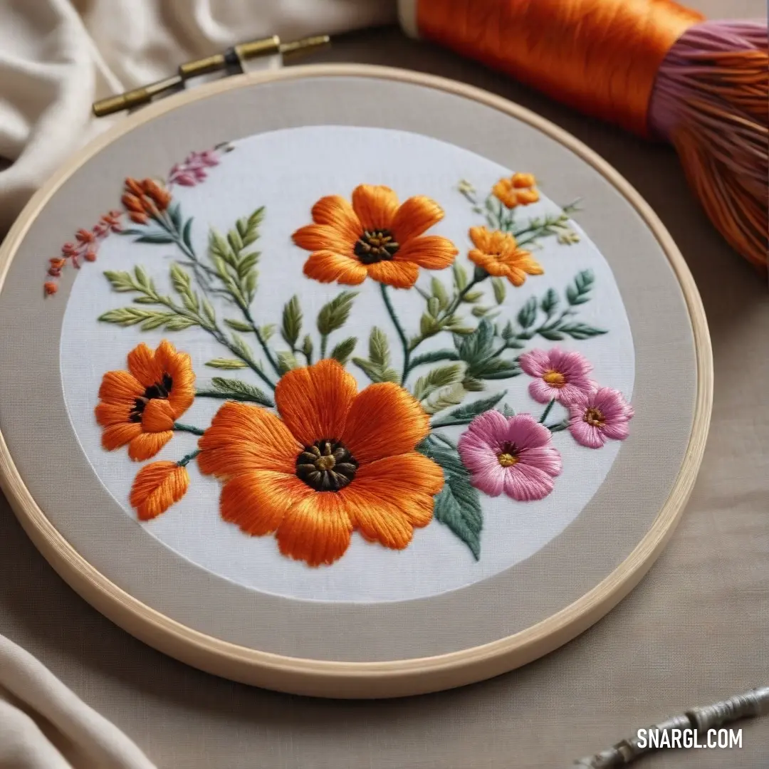 Close up of a embroidery on a table with a needle and a piece of thread and a flower. Color Sinopia.