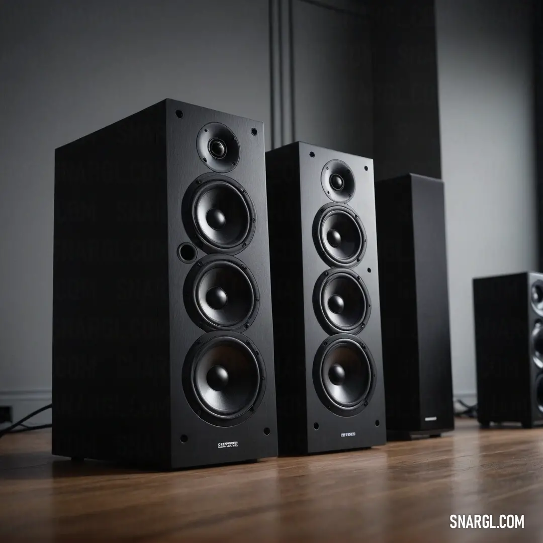 A captivating collection of speakers atop a stylish wooden floor, positioned next to a modern wall-mounted speaker system. This arrangement invites you into a world of immersive soundscapes and modern design.