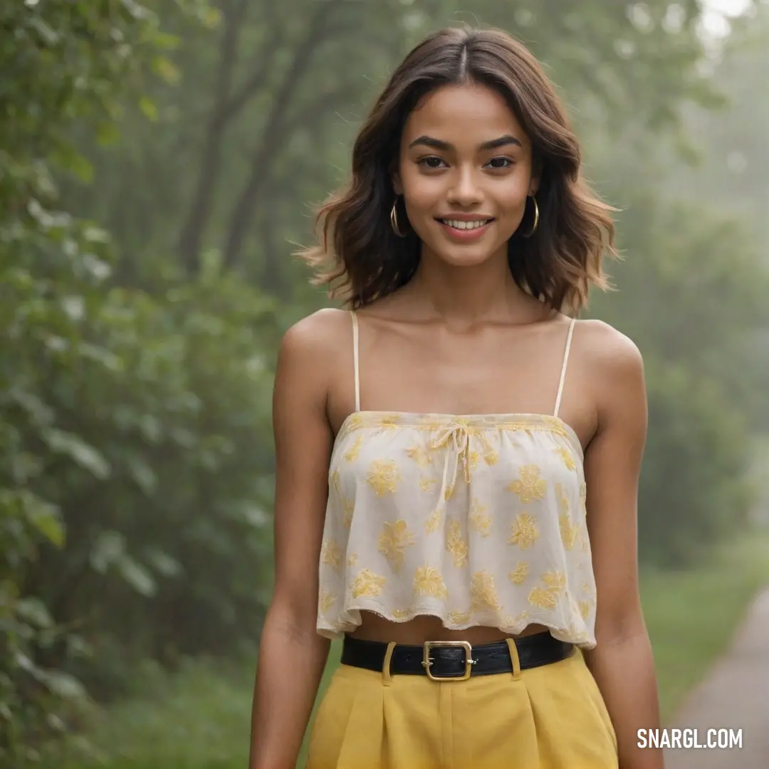 Woman standing in the middle of a forest wearing a yellow skirt and a white top with a yellow flowered design