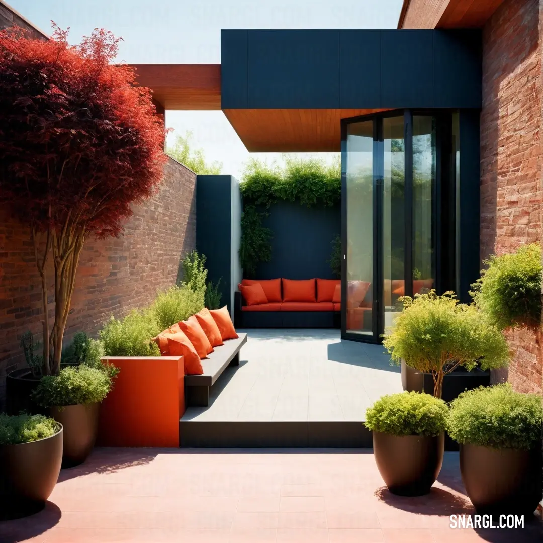 Patio with a couch and some plants in it and a red couch in the middle of the patio. Color #FD5E53.