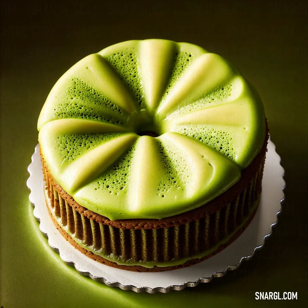 Cake with a green frosting design on top of it on a plate on a green surface with a white border