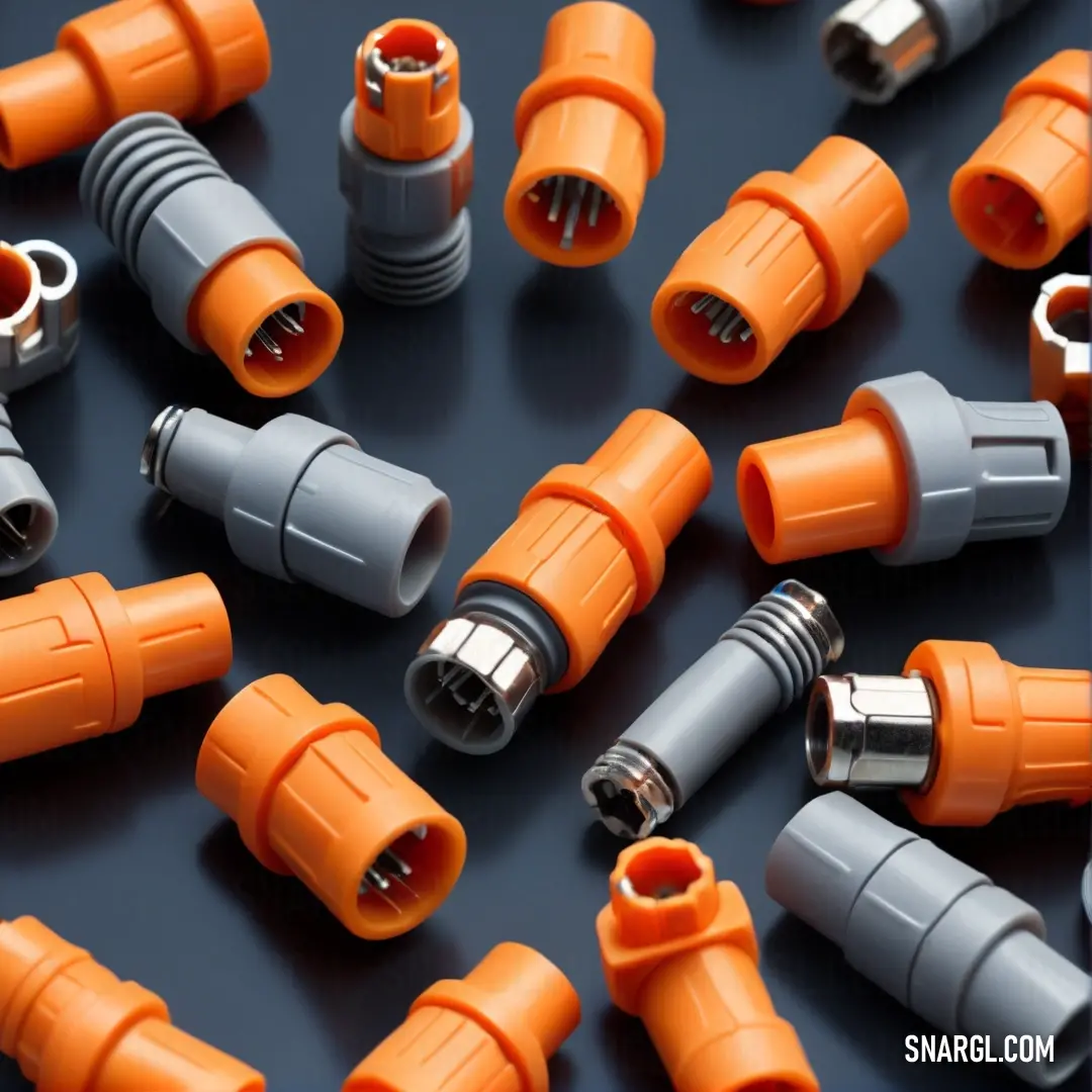 A captivating arrangement of orange and gray electrical wires sprawls across a dark table, showcasing their connections and textures in a visually striking composition that hints at the complexity of electrical works.