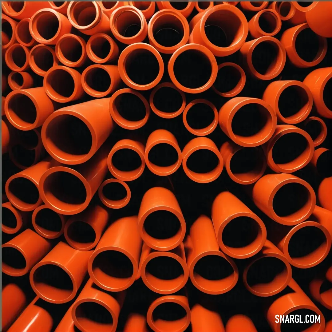 Tangelo color. Pile of orange pipes stacked on top of each other in a pile together in a pile with a black background