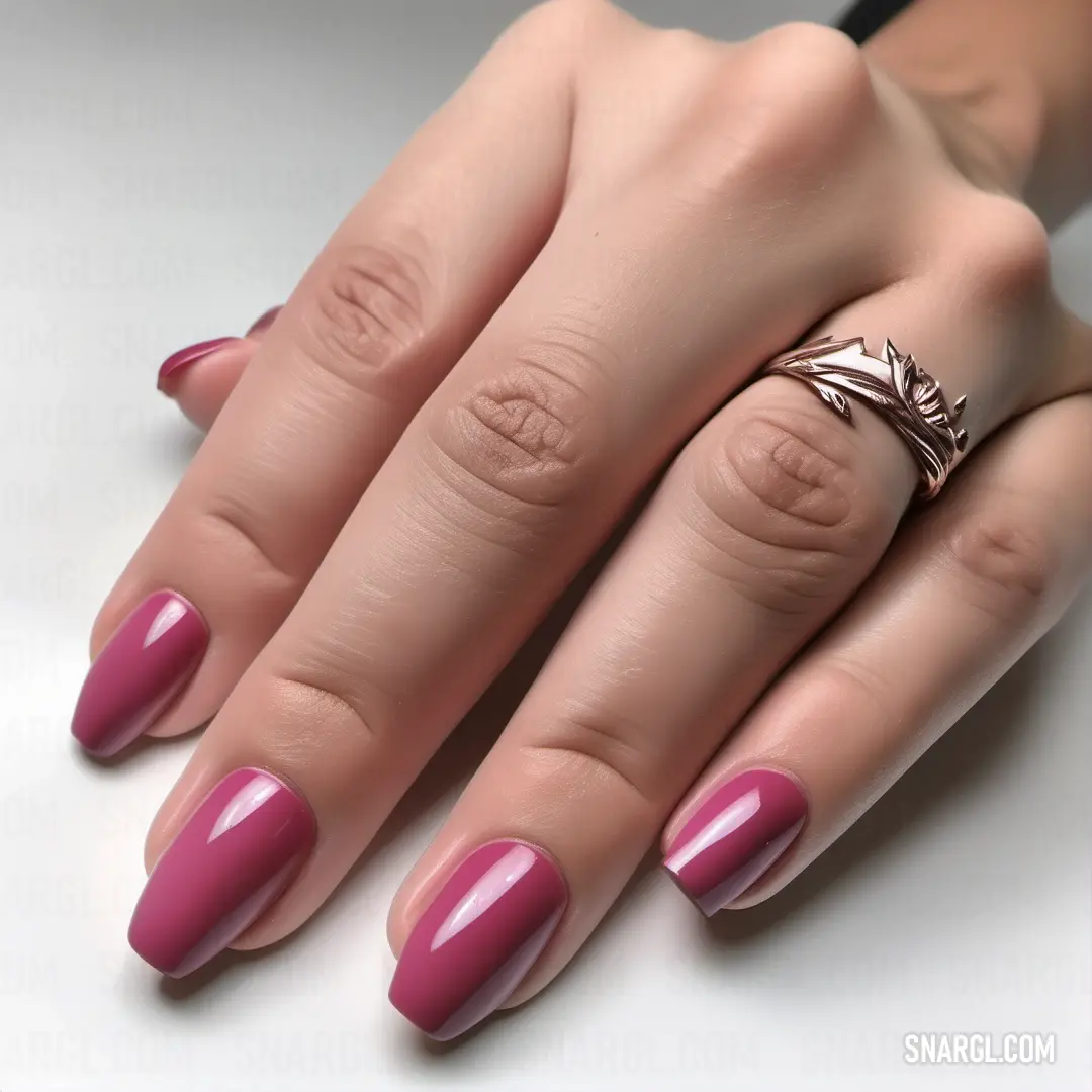 Tickle Me Pink color. Woman's hand with a ring on it and a manicure on her nails