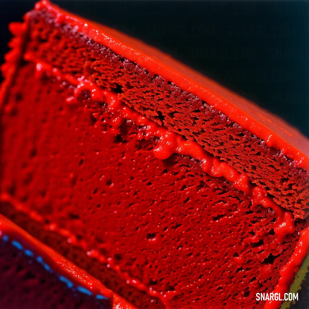 Close up of a red object with water droplets on it's surface and a black background behind it