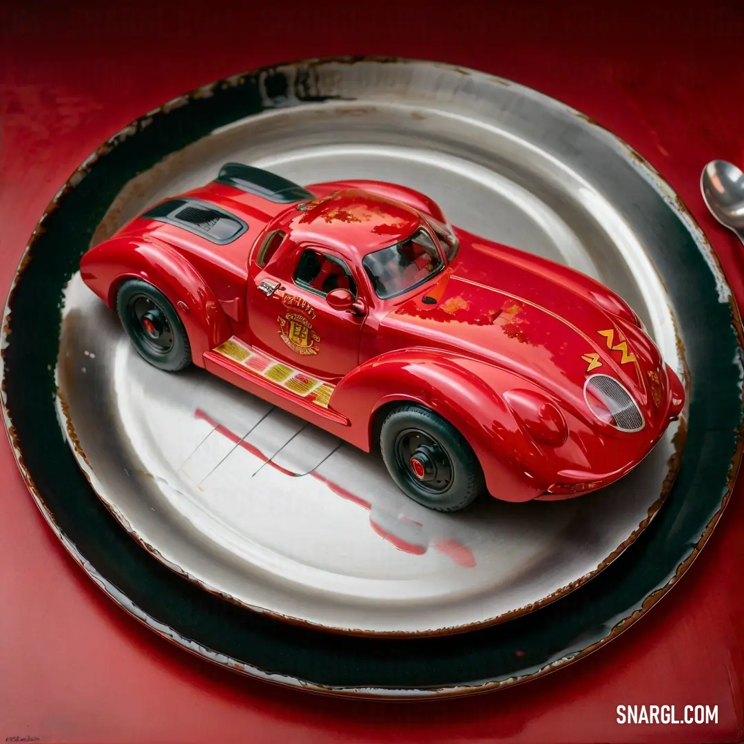 Red toy car on a plate with a spoon and fork on a table top with a red table cloth. Example of Transport Red color.