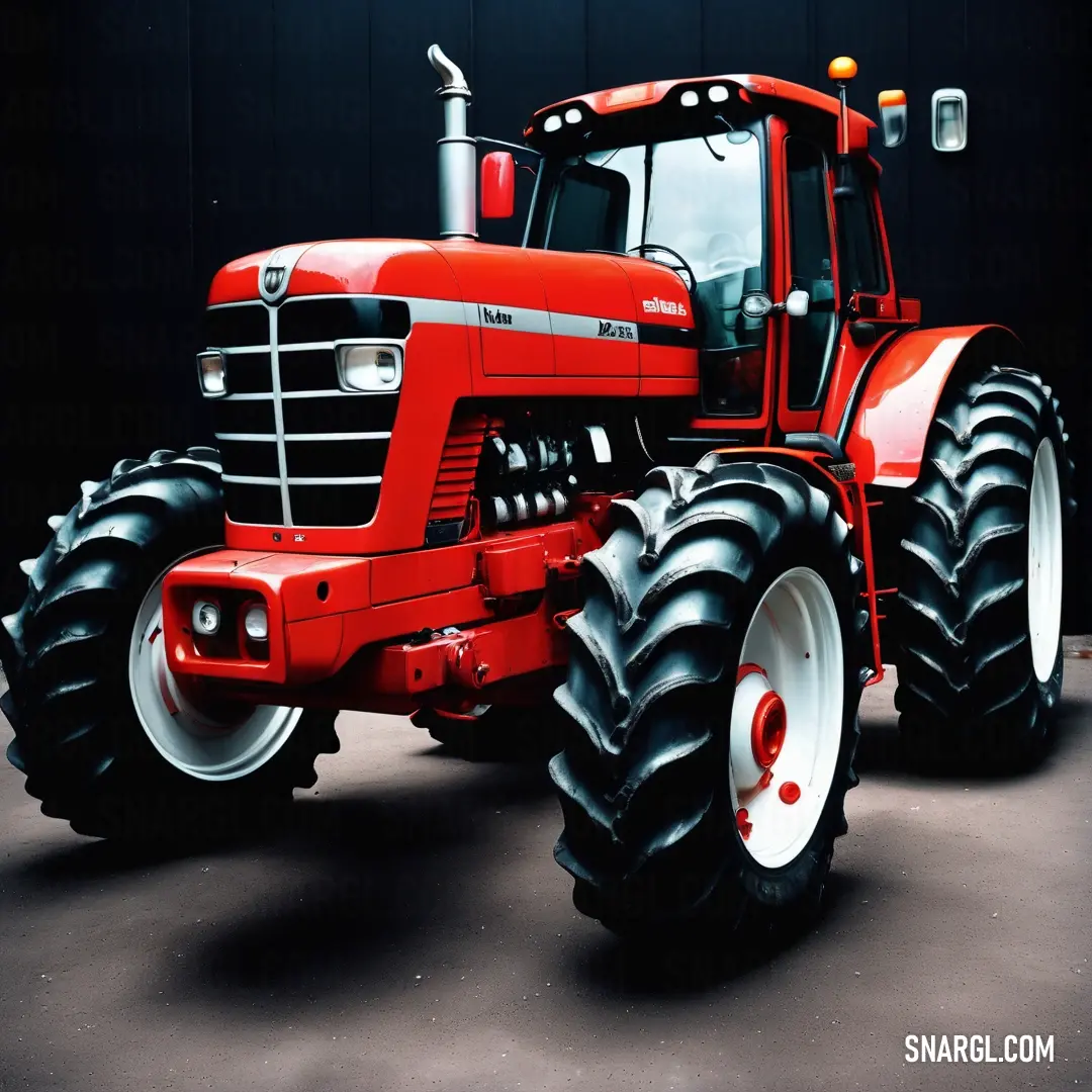 Red tractor with big tires parked in a garage area with a black background and a black wall behind it