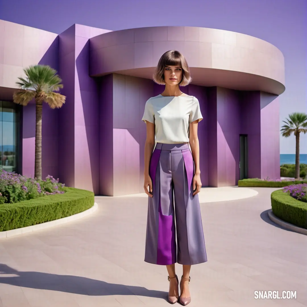 Woman standing in front of a building with a purple and white top and purple pants