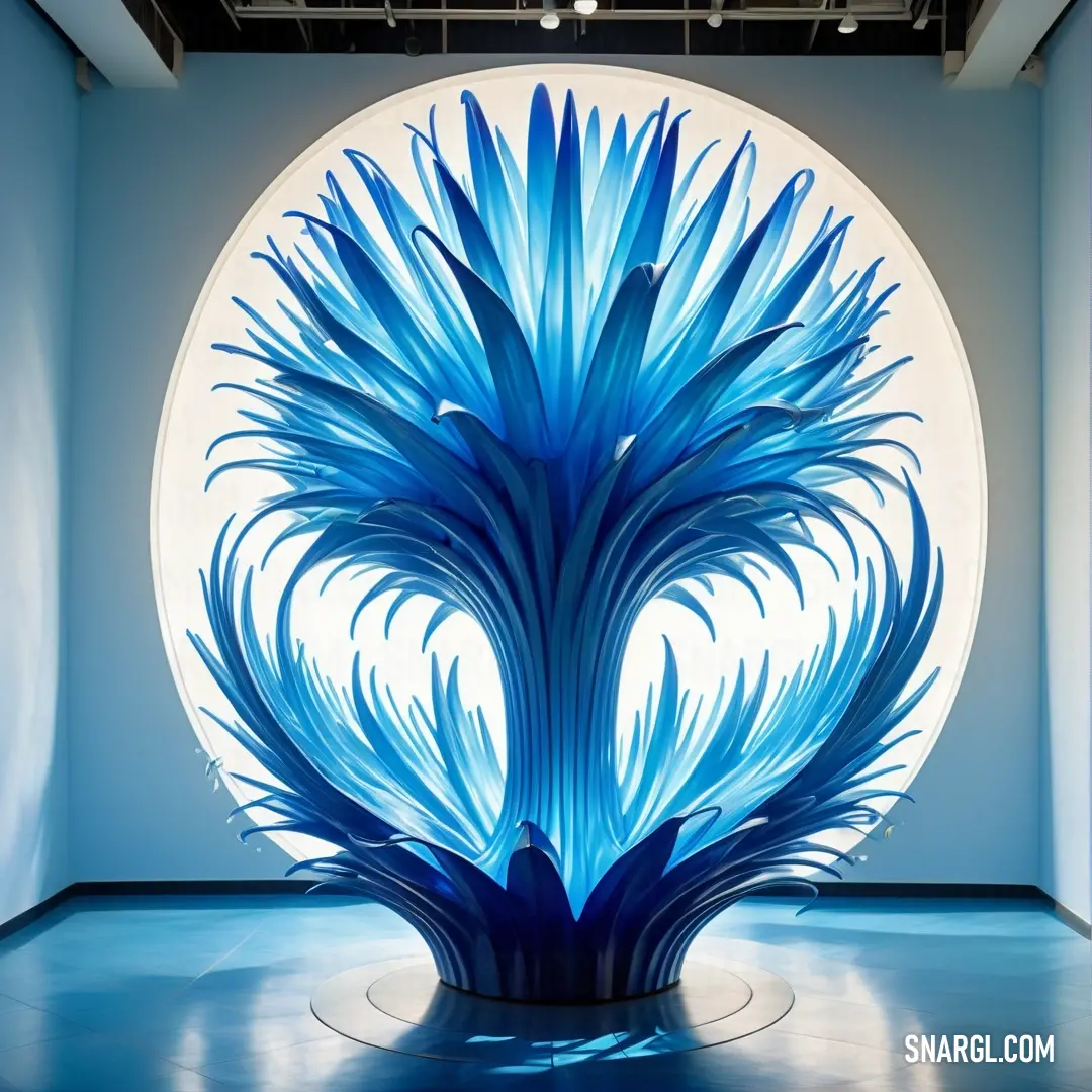 Blue sculpture in a room with a circular window behind it and a circular light fixture above it that has a blue flower on it