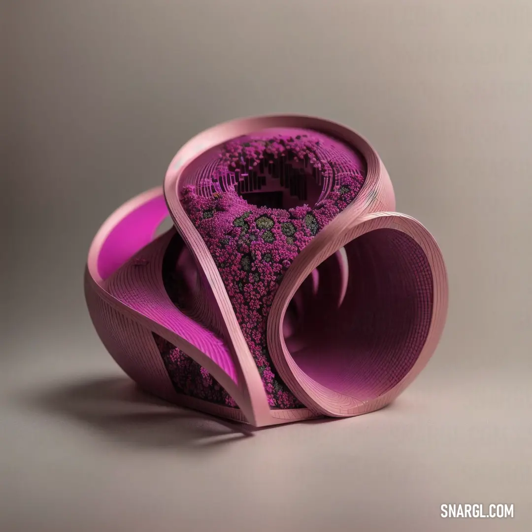 Sculpture made of pink and purple material on a gray background with a black and white design on the bottom