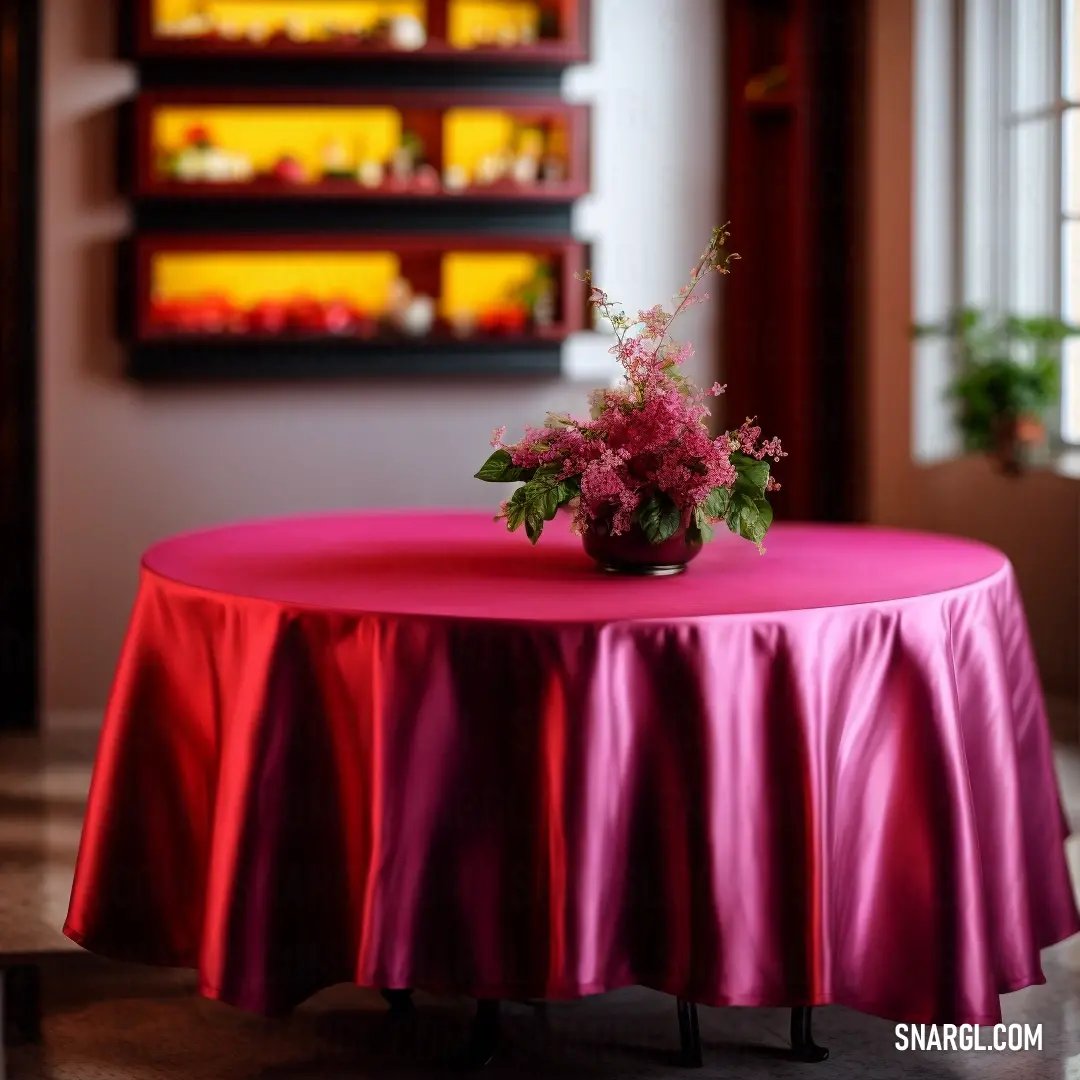 Vase with flowers on a table in a room with a red table cloth on it and a red wall behind it