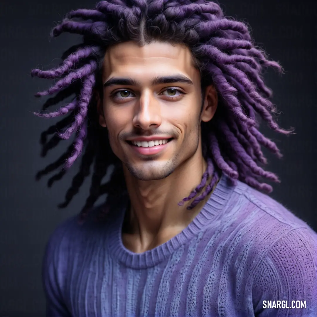 Man with purple dreadlocks smiling for a picture in a purple sweater with a black background