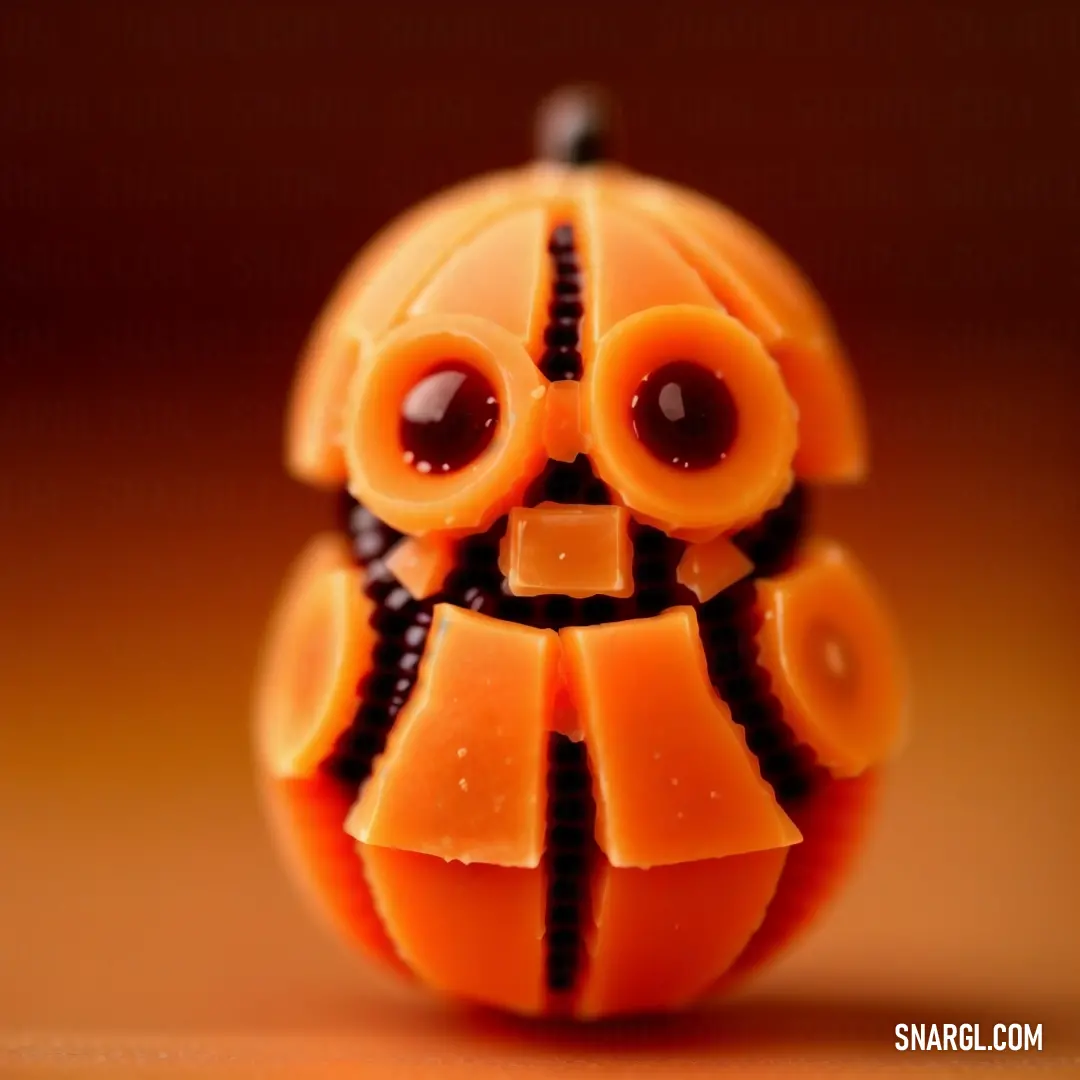 Close up of a toy with a face made of orange slices and black beads on it's eyes