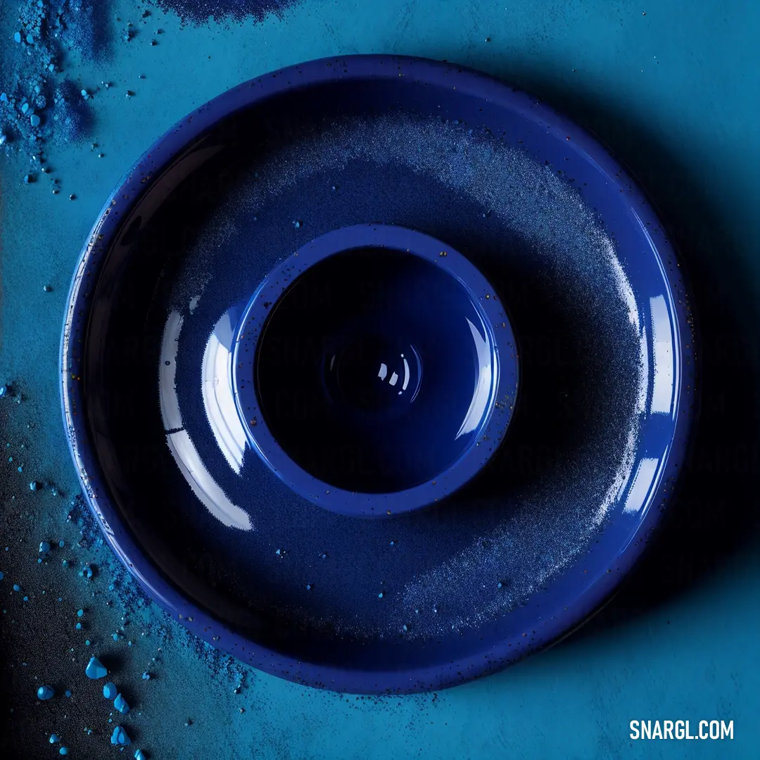 Blue bowl with a black rim on a blue surface with blue bubbles on it