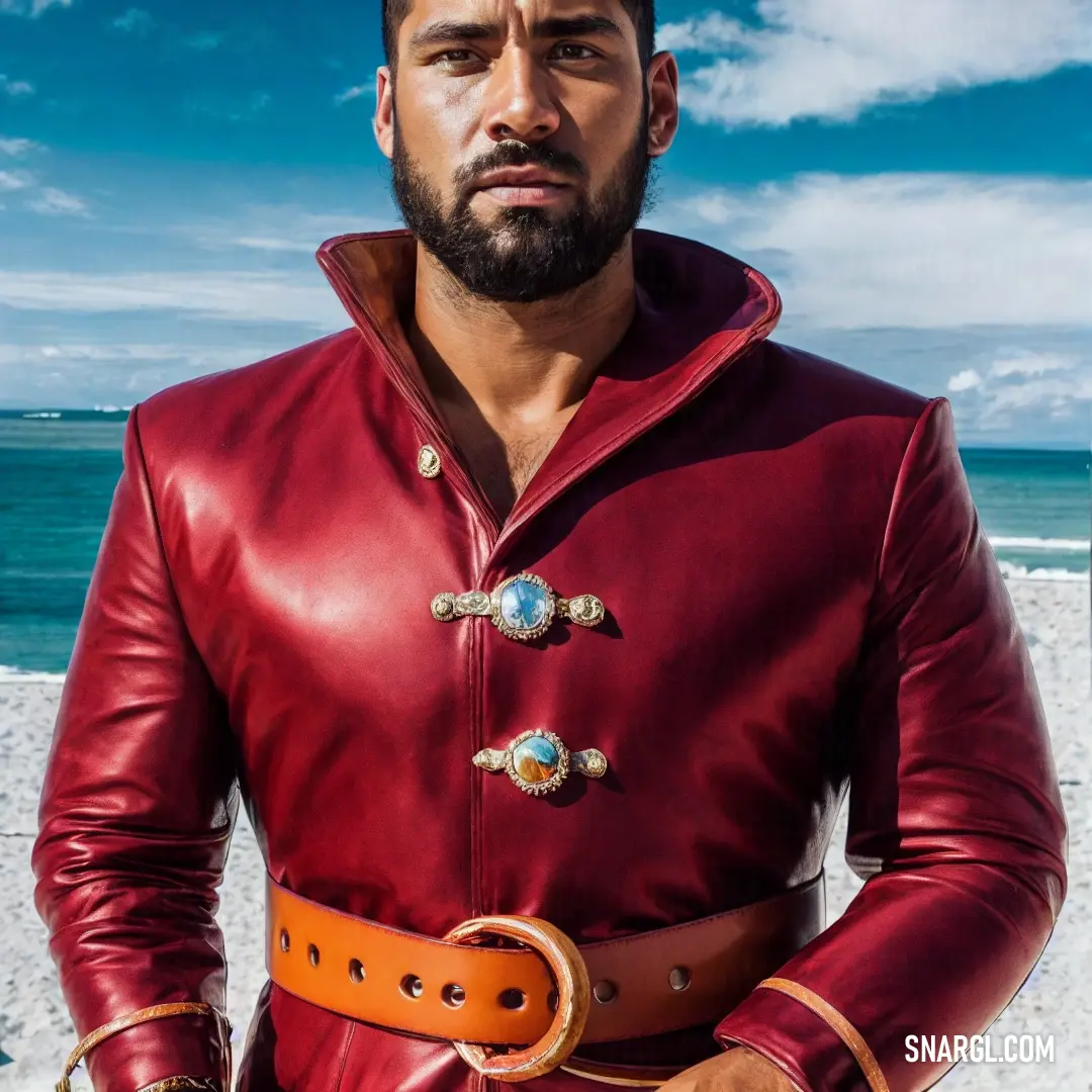 Man in a red leather jacket standing on a beach with his hands in his pockets and a belt around his waist