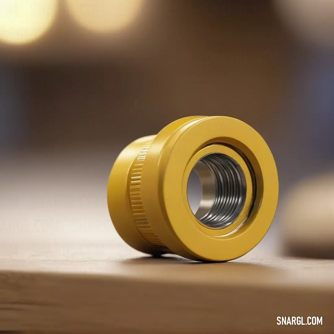 Yellow metal knob with a hole in the middle of it on a table with a blurry background. Example of Urobilin color.