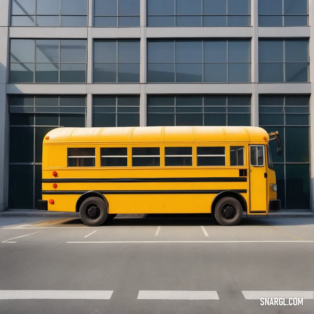 Yellow school bus parked in front of a building with windows on the side of it. Color USC Gold.