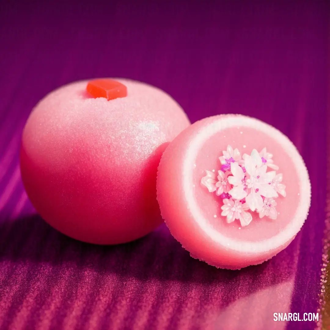 Pink dessert with a flower on top of it on a purple surface with a pink background and a pink