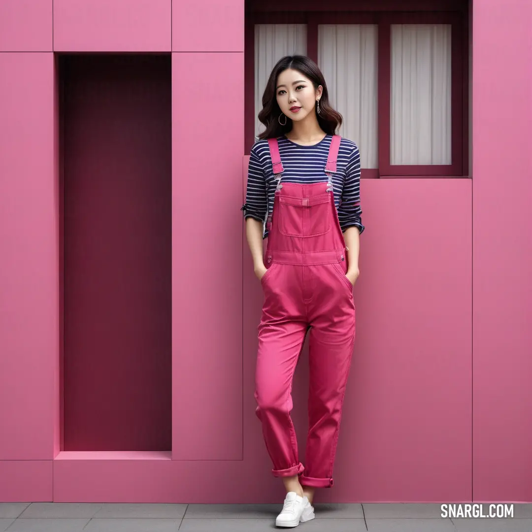 Woman standing in front of a pink wall with a striped shirt. Color Violet Red.