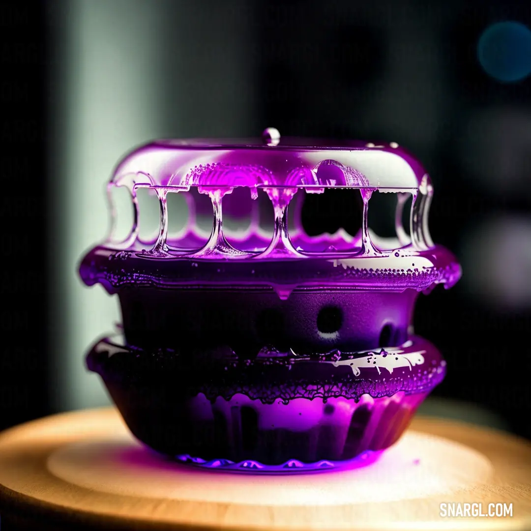 Purple cupcake dish on top of a wooden table next to a cupcake cutter. Example of CMYK 0,89,0,40 color.