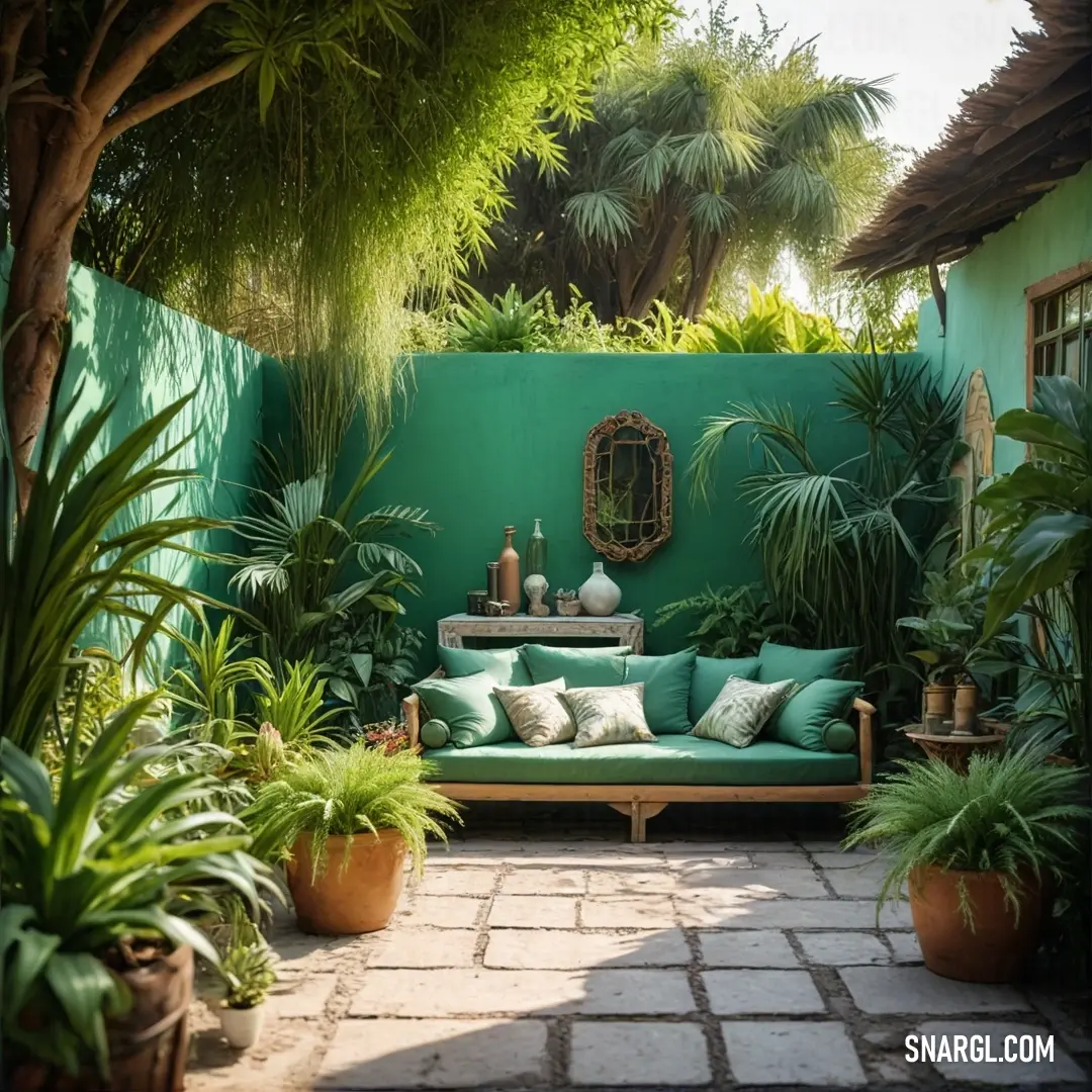 Viridian color. Green couch in a lush green garden next to a green wall