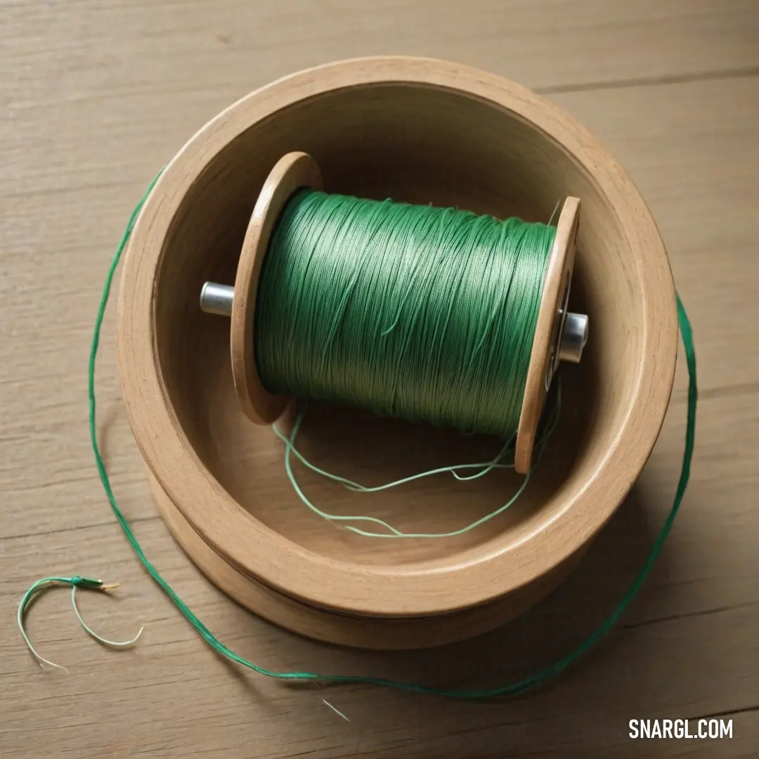 Spool of thread sits in a wooden bowl with a thread spool on the side of the bowl. Example of #40826D color.