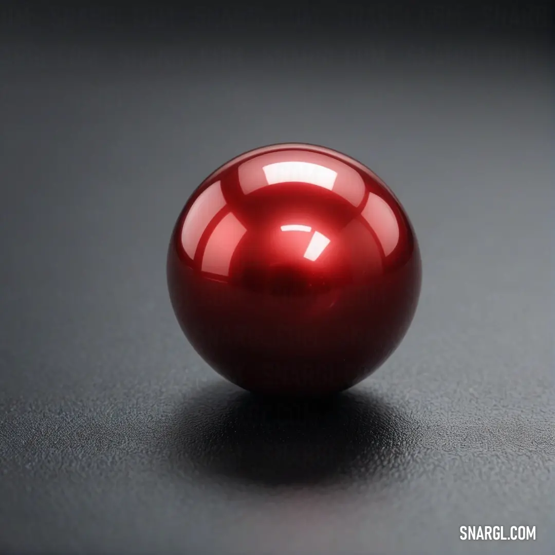 Shiny red ball on a black surface with a reflection of the light on it's surface. Example of RGB 159,29,53 color.