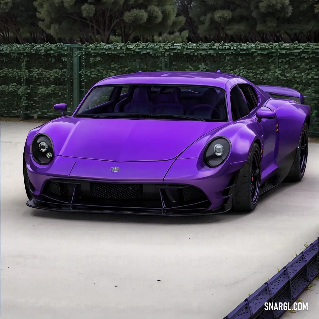 Vivid violet color. Purple sports car parked in a parking lot next to a hedge and a fenced in area