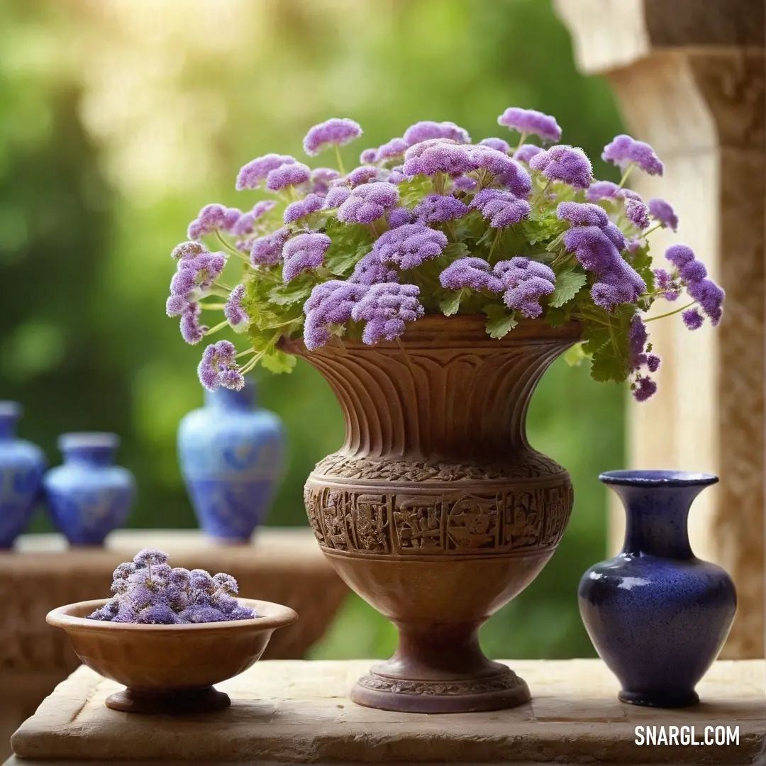Wisteria color. Vase with purple flowers and a bowl of purple flowers on a table with other vases in the background